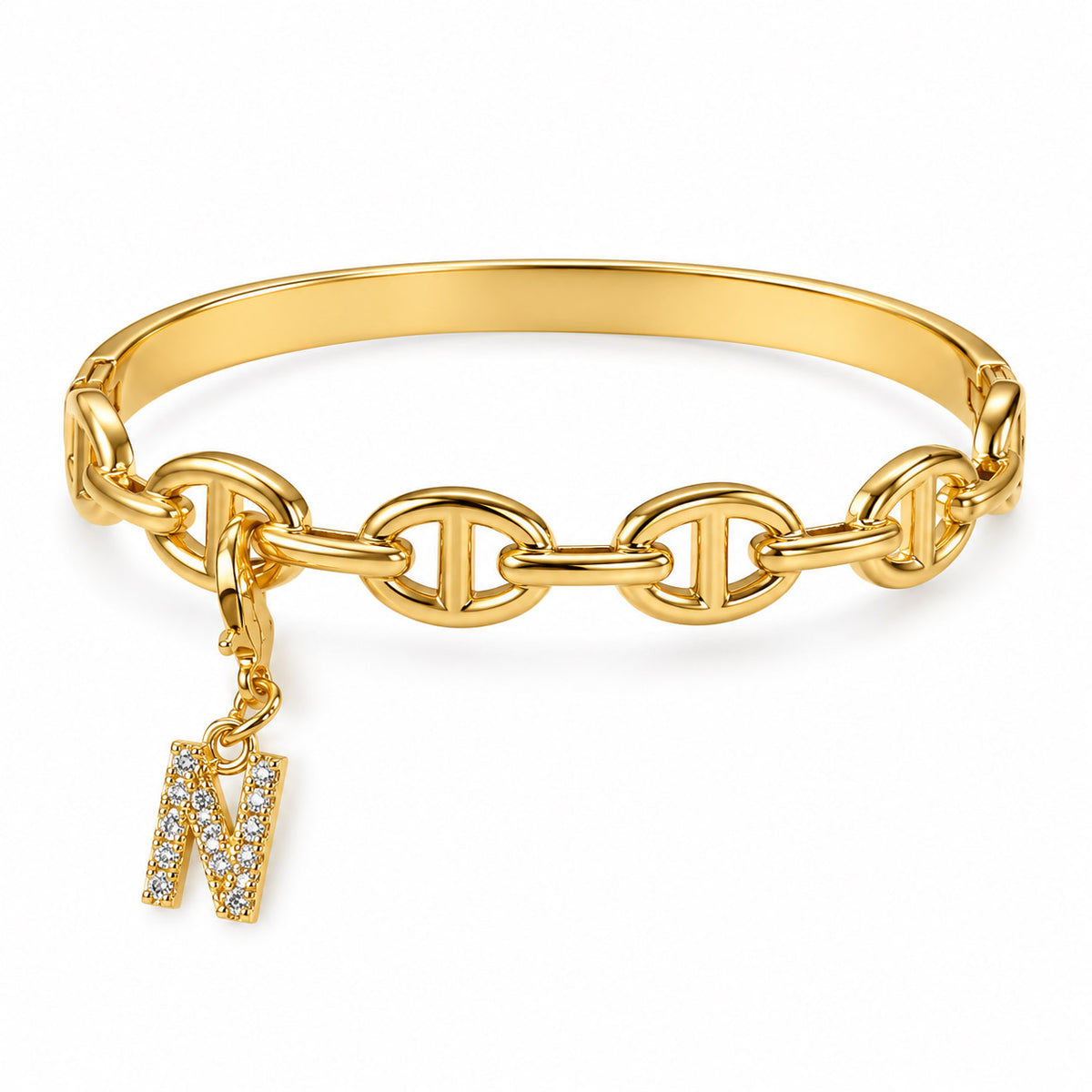 Gold-tone statement bracelet featuring a smooth cuff band, linked oval chain detailing, and a dangling crystal-studded letter “N” charm, displayed on a clean white background.