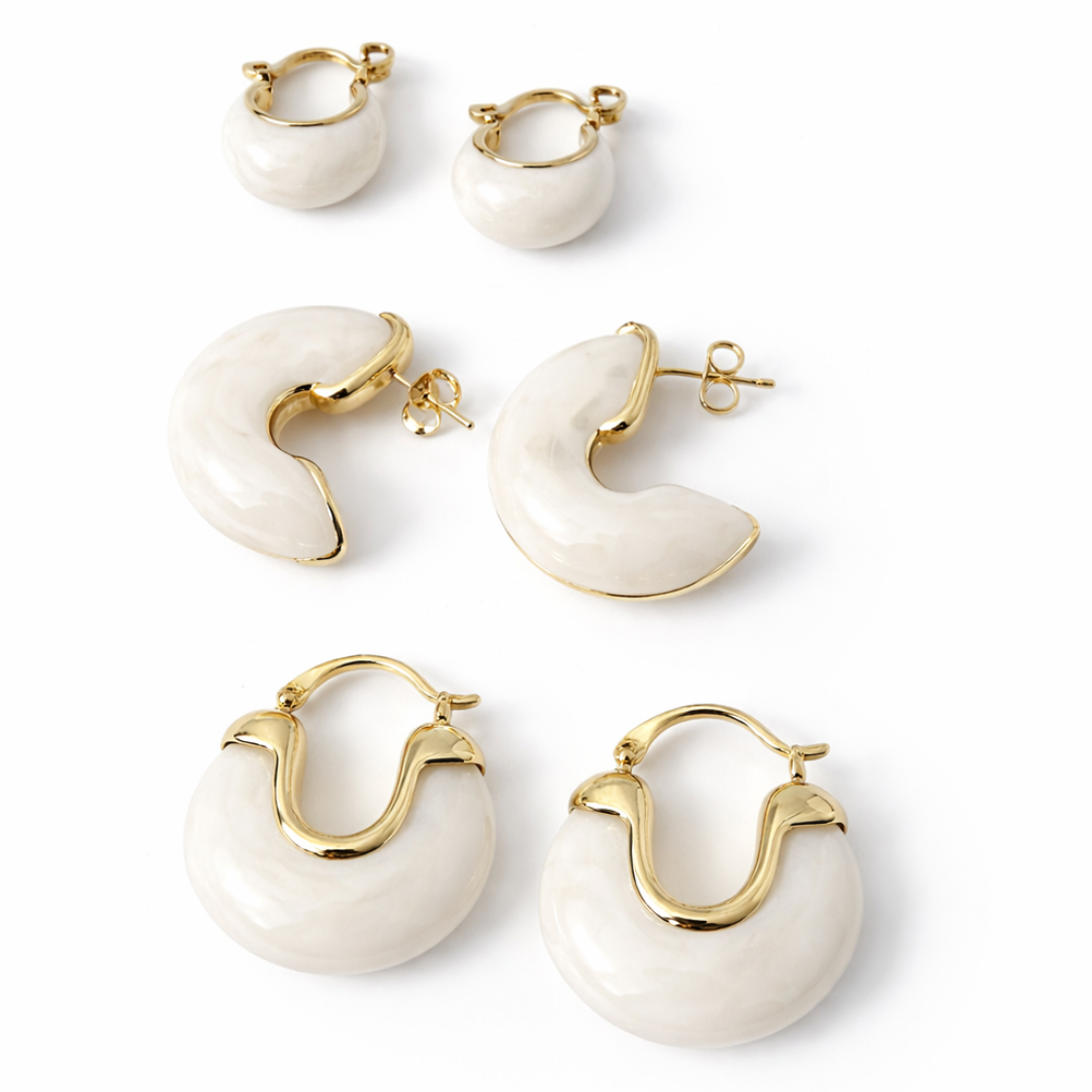Contemporary ivory hoop earrings with smooth texture and polished gold accents