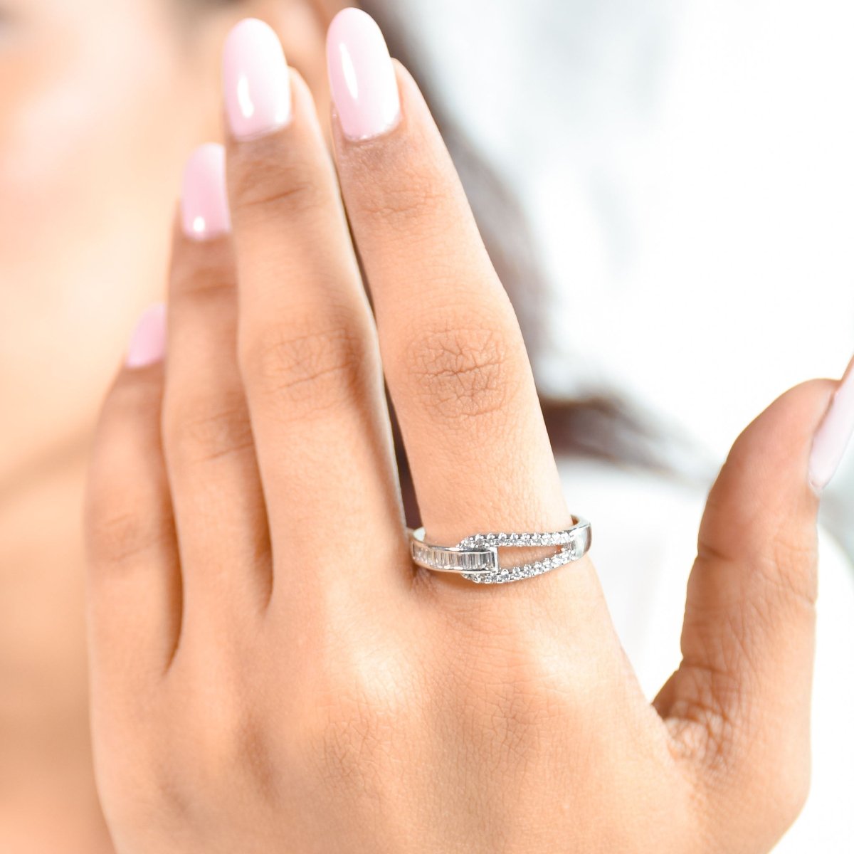 Elegant silver interlocked ring featuring baguette crystals, pavé detailing, and an anti-tarnish finish, perfect for modern styling, statement looks, and everyday sophistication.