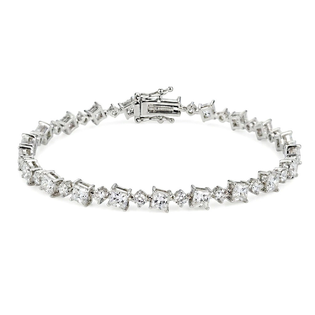 Silver-tone tennis bracelet with square-cut and round clear stones in a delicate linked design, displayed on a white background