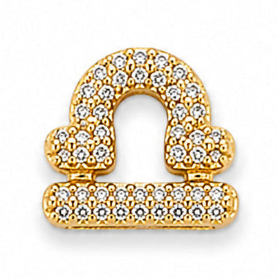 Gold-tone Libra zodiac charm featuring the iconic balanced scales symbol, intricately embellished with numerous small white rhinestones. The charm has a polished metallic finish, raised detailing, and a sparkling, elegant appearance, isolated against a clean white background.