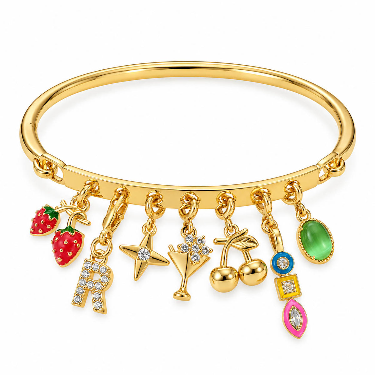 Gold-tone charm bracelet featuring a smooth cuff band with multiple dangling charms, including strawberries, a crystal-studded letter “R,” star, cocktail glass, floral charm, cherries, blue evil eye, green gemstone, and colorful geometric charms, displayed on a clean white background.