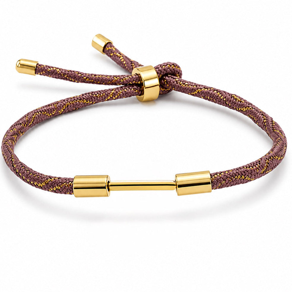 Burgundy braided cord bracelet with gold-tone woven detailing, a central sliding clasp, and gold-tone end caps, displayed on a clean white background.