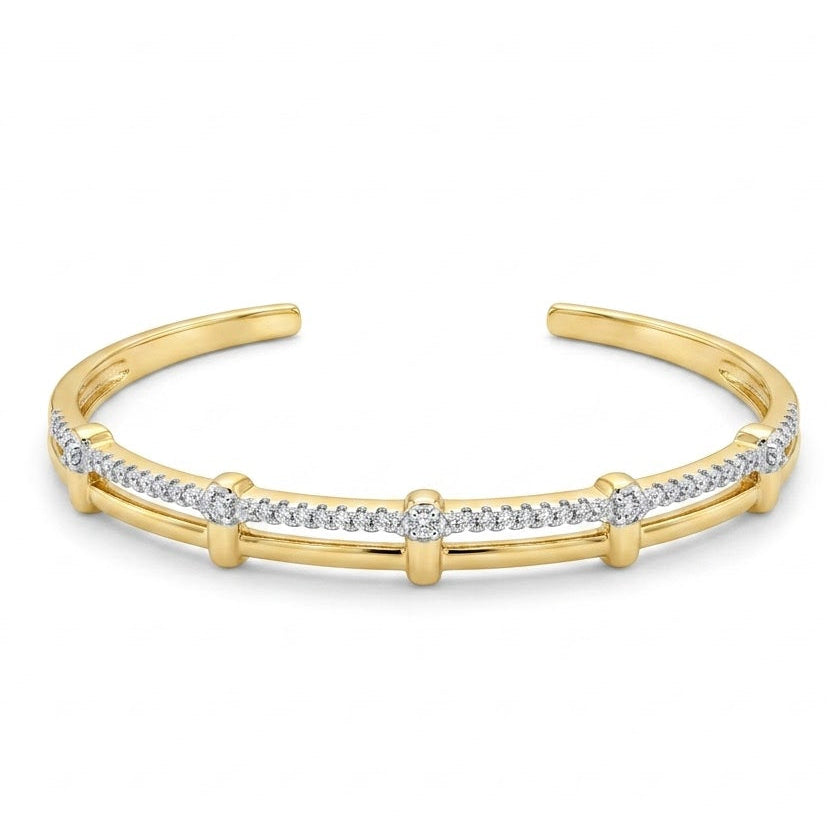 Anti-tarnish yellow gold open cuff bracelet featuring a dual-strand design with an upper pavé cubic zirconia row joined to a smooth bottom band by vertical gold bars,on a white background .