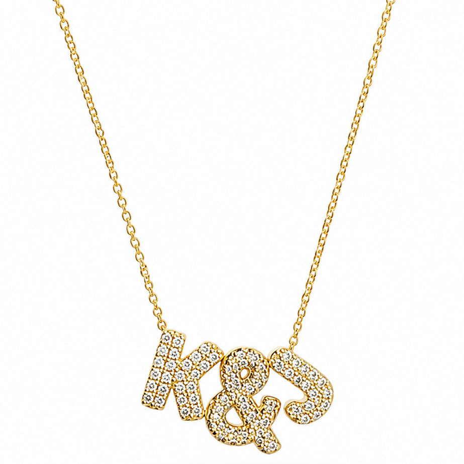 Gold-plated personalized necklace featuring sparkling pavé initials “K & J” on a delicate chain, displayed on a clean white background.