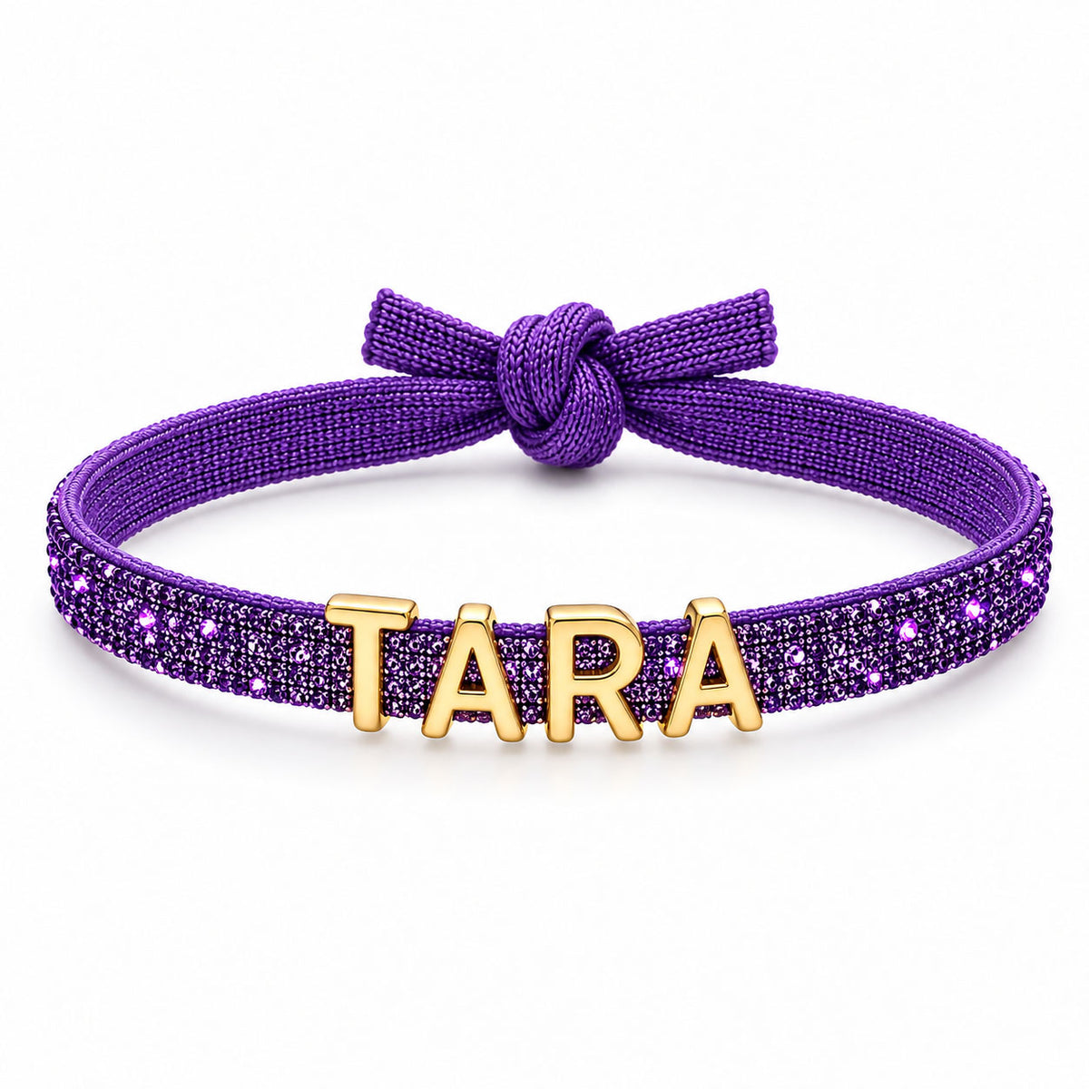 Purple glittery adjustable bracelet featuring a knotted bow detail and gold-tone TARA letter charms across the front.