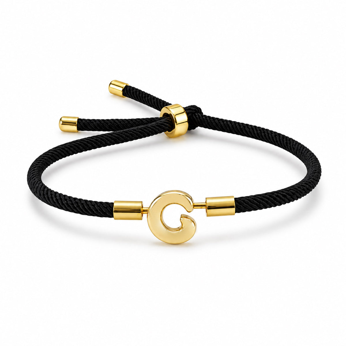 Gold-tone initial “G” charm bracelet with a black braided cord, polished gold accents, and an adjustable sliding closure, displayed on a clean white background.