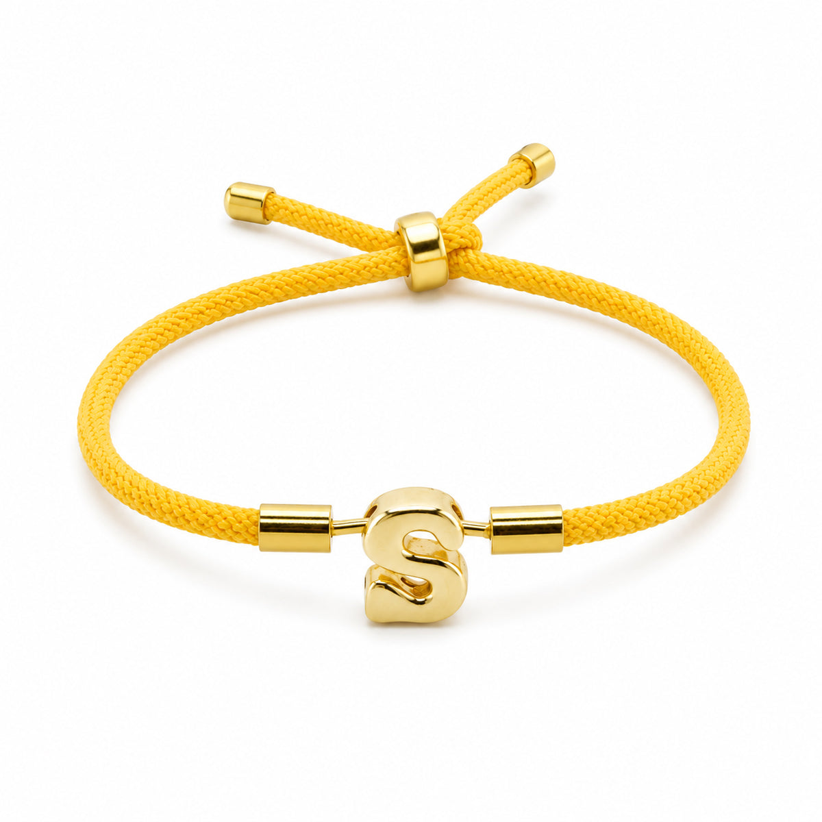 Gold-tone initial “S” charm bracelet with a bright yellow braided cord, polished gold accents, and an adjustable sliding closure, displayed on a clean white background.