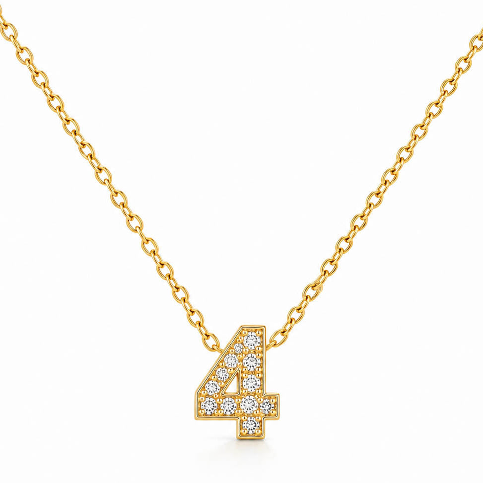 A studio shot of a thin gold link necklace centered with a small number "4" charm entirely encrusted with sparkling rhinestones.