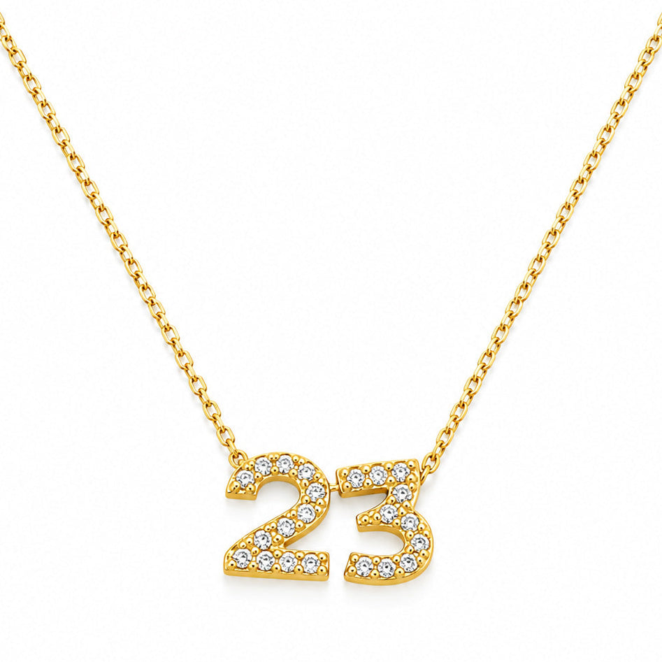 Gold-plated personalized number necklace featuring a sparkling pavé “23” pendant on a delicate gold chain, displayed against a clean white background.