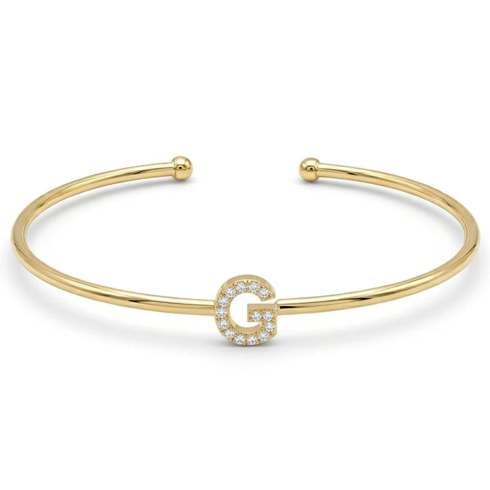 Elegant gold-tone adjustable open cuff bangle featuring a pavé crystal-studded letter G centerpiece. The personalized initial bangle has a sleek polished finish with rounded ball ends and is displayed on a clean white background, making it perfect for everyday wear, stacking, gifting, and personalized jewellery collections.