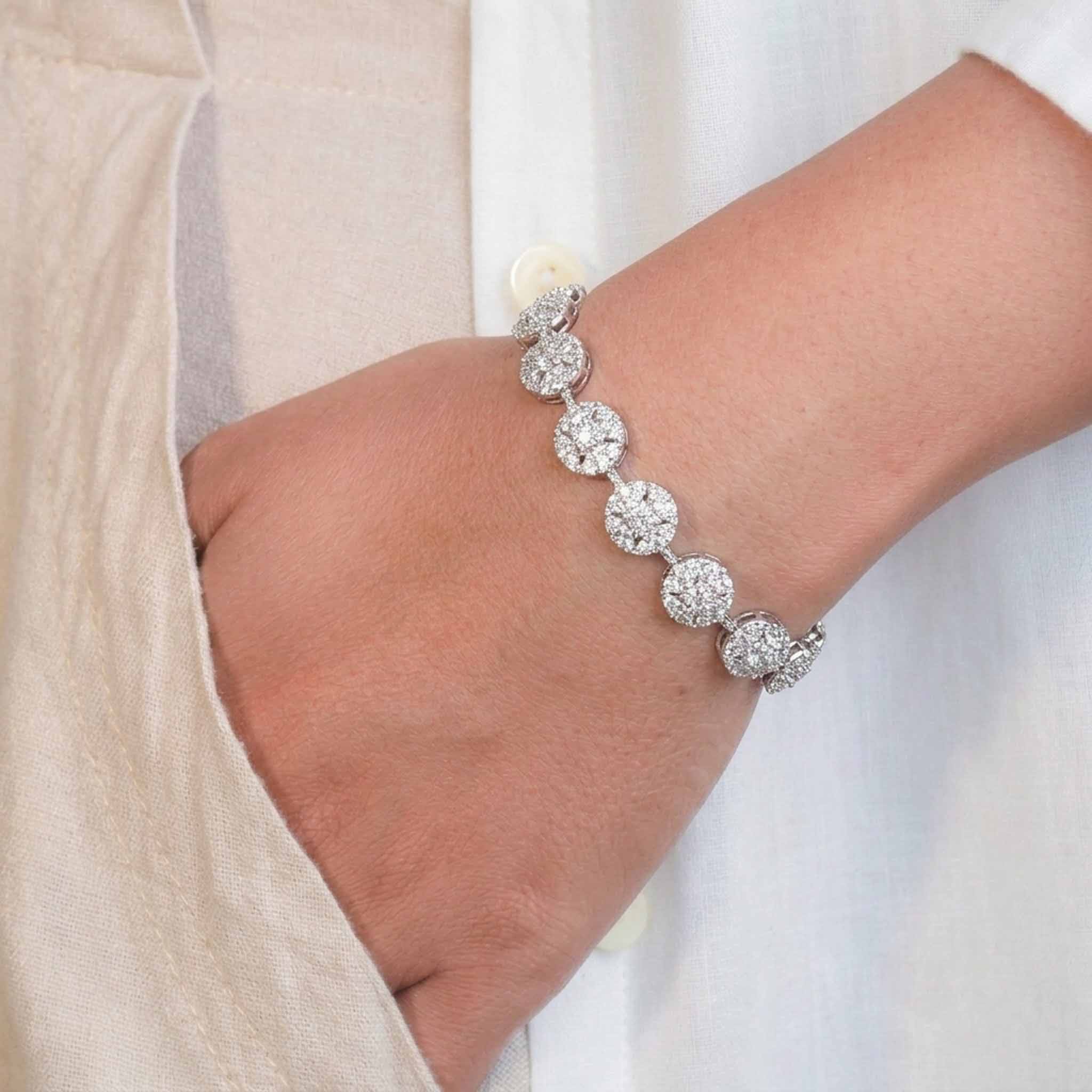 Round Pave Crystal Tennis Bracelet in Silver Tone with Secure Box Clasp, Worn on a Model’s Wrist in a Close-Up Product Portrait