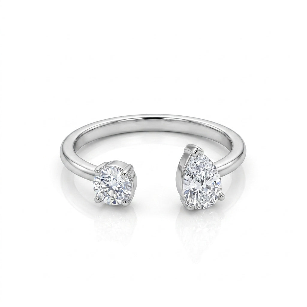 Silver open-ring featuring a round-cut crystal and pear-cut crystal in a modern bypass design, displayed on a white background.