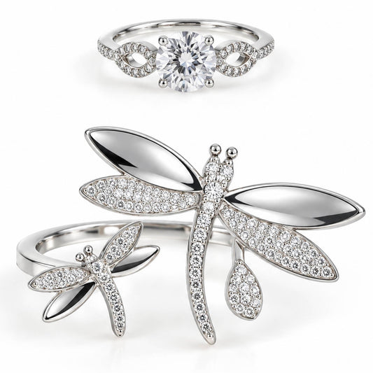 A product photo of two silver-tone rings featuring a solitaire crystal band with infinity-knot shoulders and an open wrap-around ring adorned with large, crystal-paved dragonfly motifs.