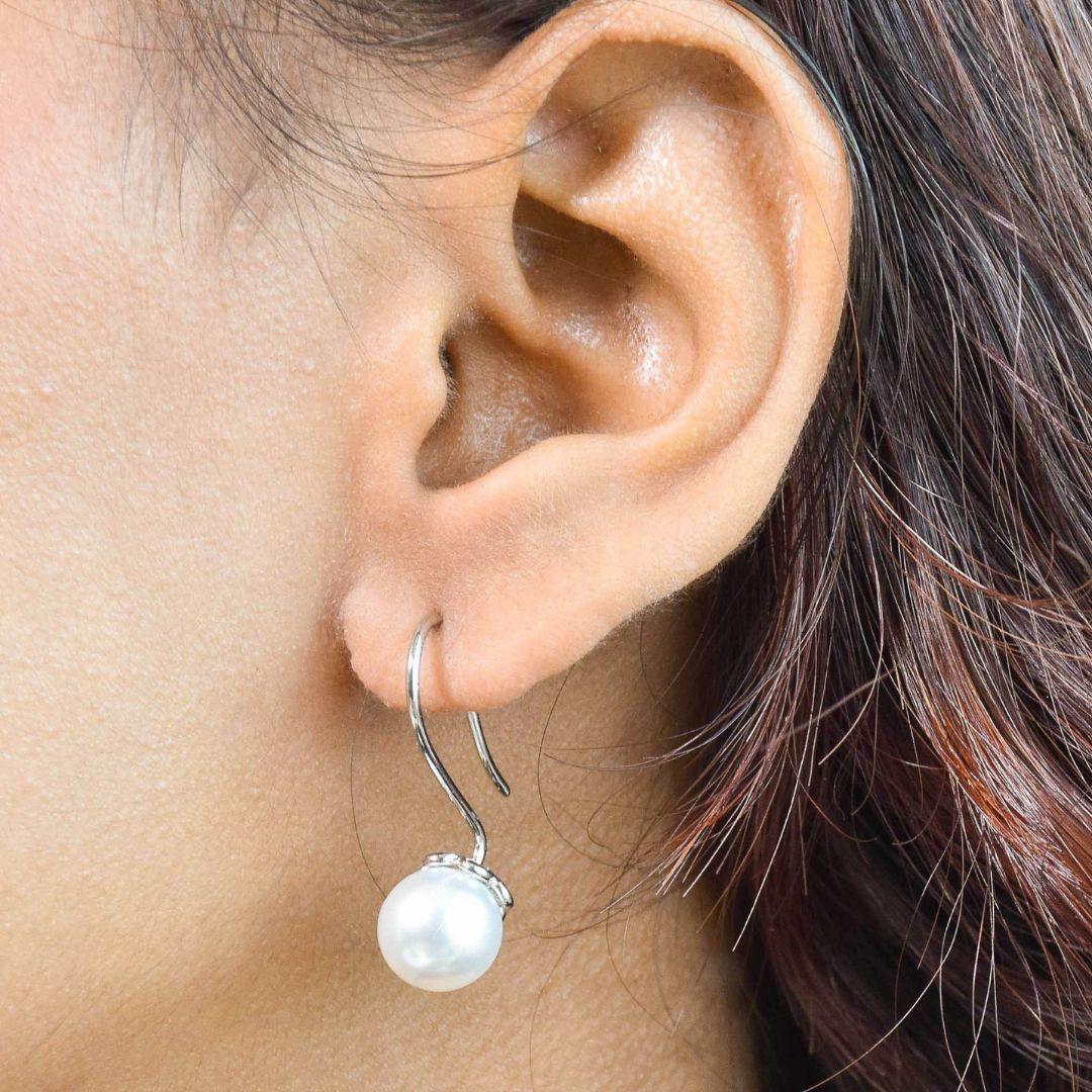 Elegant pearl drop earrings with luminous pearl detailing and an anti-tarnish gold finish, perfect for everyday wear and timeless styling.