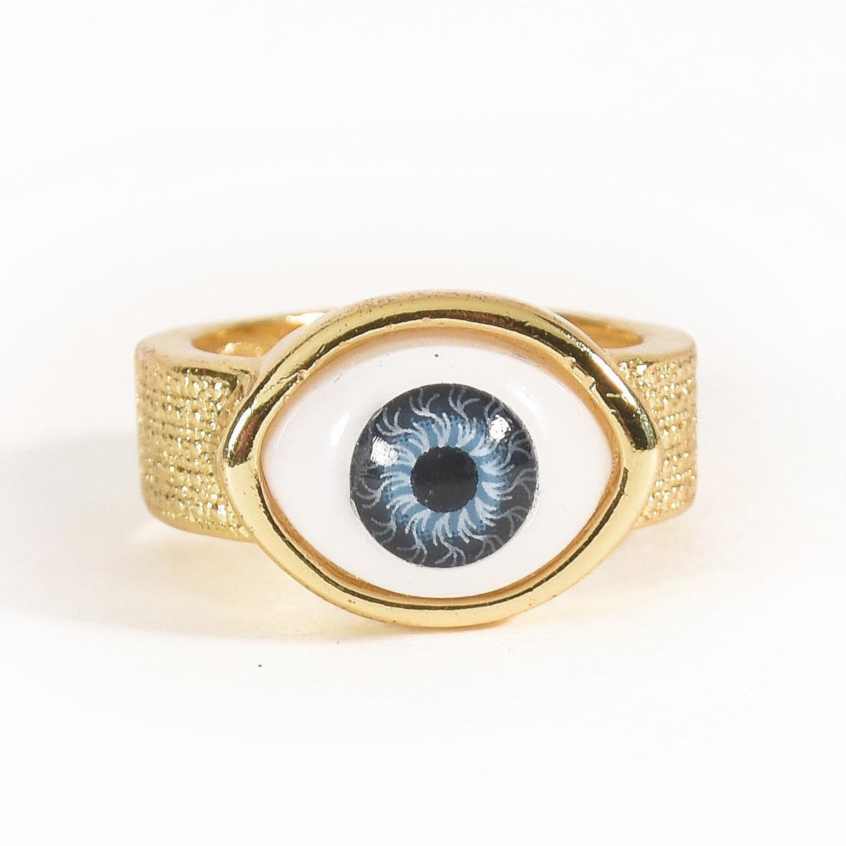 A stack of three adjustable gold-toned rings: a sculptural spike spiral, a chunky chain-link band, and a central signet ring featuring an evil eye symbol.