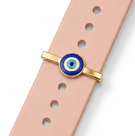 Zoomed-out view of a blue evil eye watch charm with a gold-tone frame, attached to a blush pink watch strap, displayed on a clean white background.