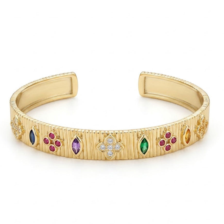 Elegant gold-tone adjustable open cuff bangle featuring a textured ribbed finish with colorful marquise and round gemstone accents, highlighted by a sparkling crystal floral motif at the center. The anti-tarnish statement bangle is displayed on a clean white background, making it perfect for everyday wear, festive occasions, stacking, and gifting.
