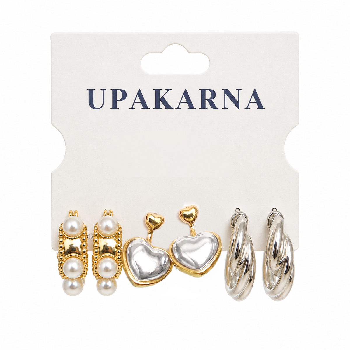 Upakarna earring card displaying three pairs of earrings: pearl-accented gold rectangular earrings, two-tone heart earrings, and polished silver-tone twisted hoops.