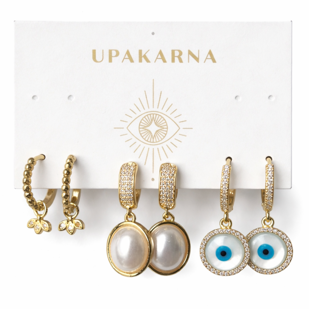 Gold earring stack with diamond petal, pearl and evil eye drops