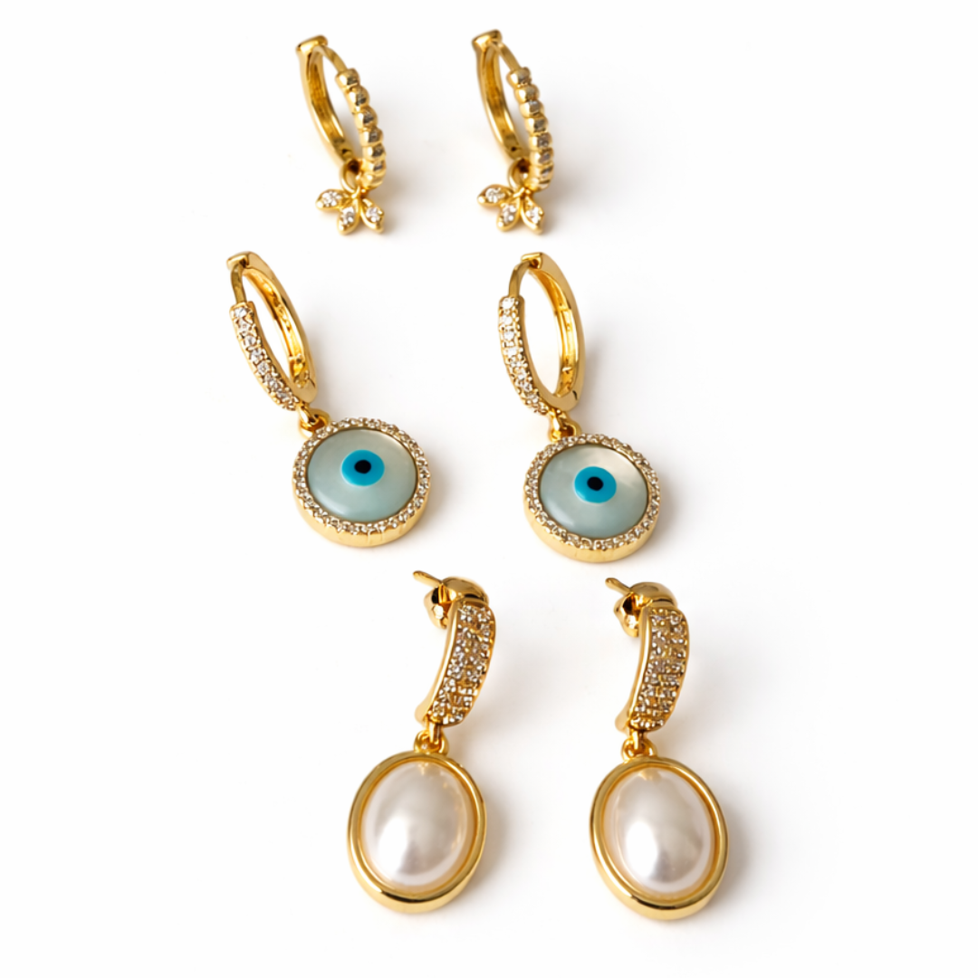 Gold earring stack with diamond petal, pearl and evil eye drops