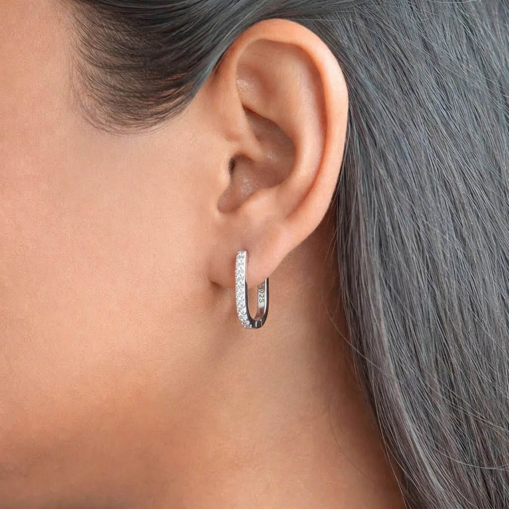 Luna Shine 925 Sterling Silver hoop earrings featuring a sleek elongated oval design accented with a row of sparkling cubic zirconia stones along the front edge