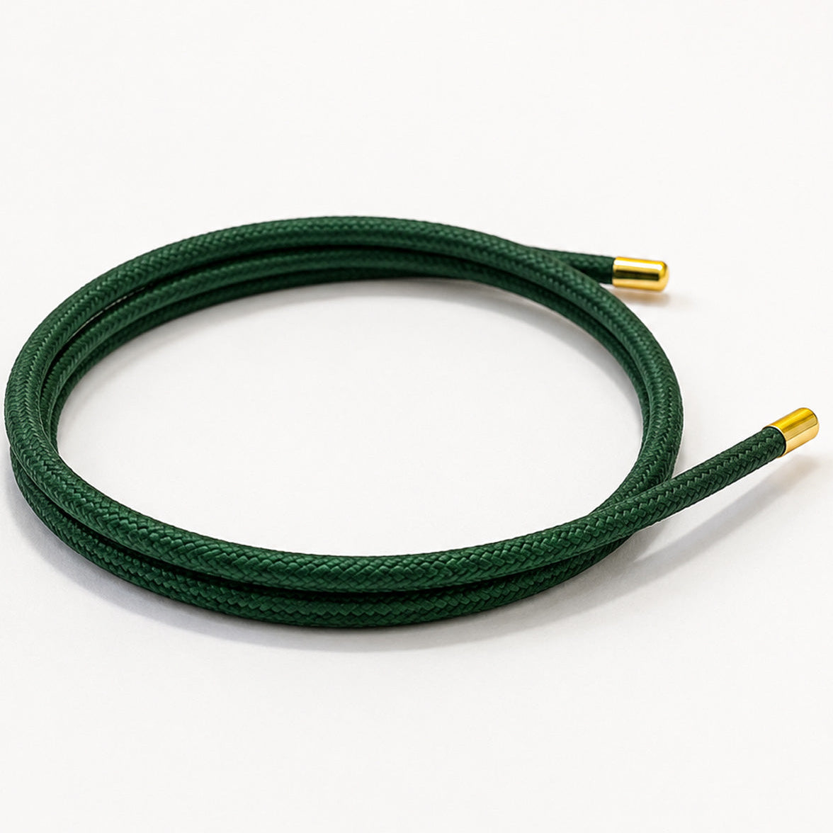 Emerald green magnetic mesh wrap bracelet with polished gold end caps coiled on a white background.