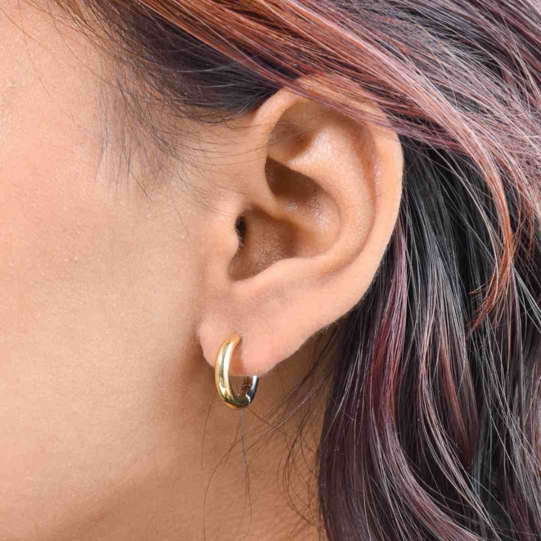 Metallic glide hoop earrings with a two-tone sculptural design and an anti-tarnish finish, available in gold and silver, perfect for everyday wear and modern styling.