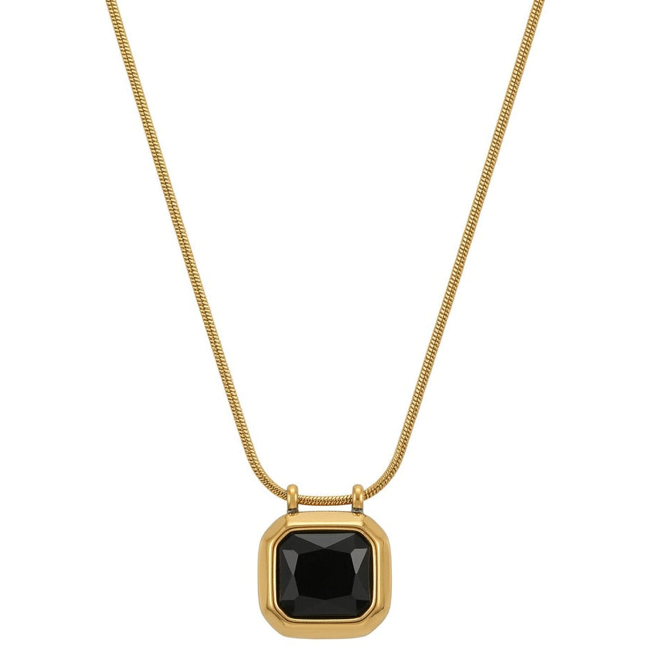 A gold necklace with a delicate snake chain holding a square-cut black gemstone pendant with faceted edges. The black stone is encased in a smooth, thick gold bezel frame, centered on a plain white background with a dark frame around the image.