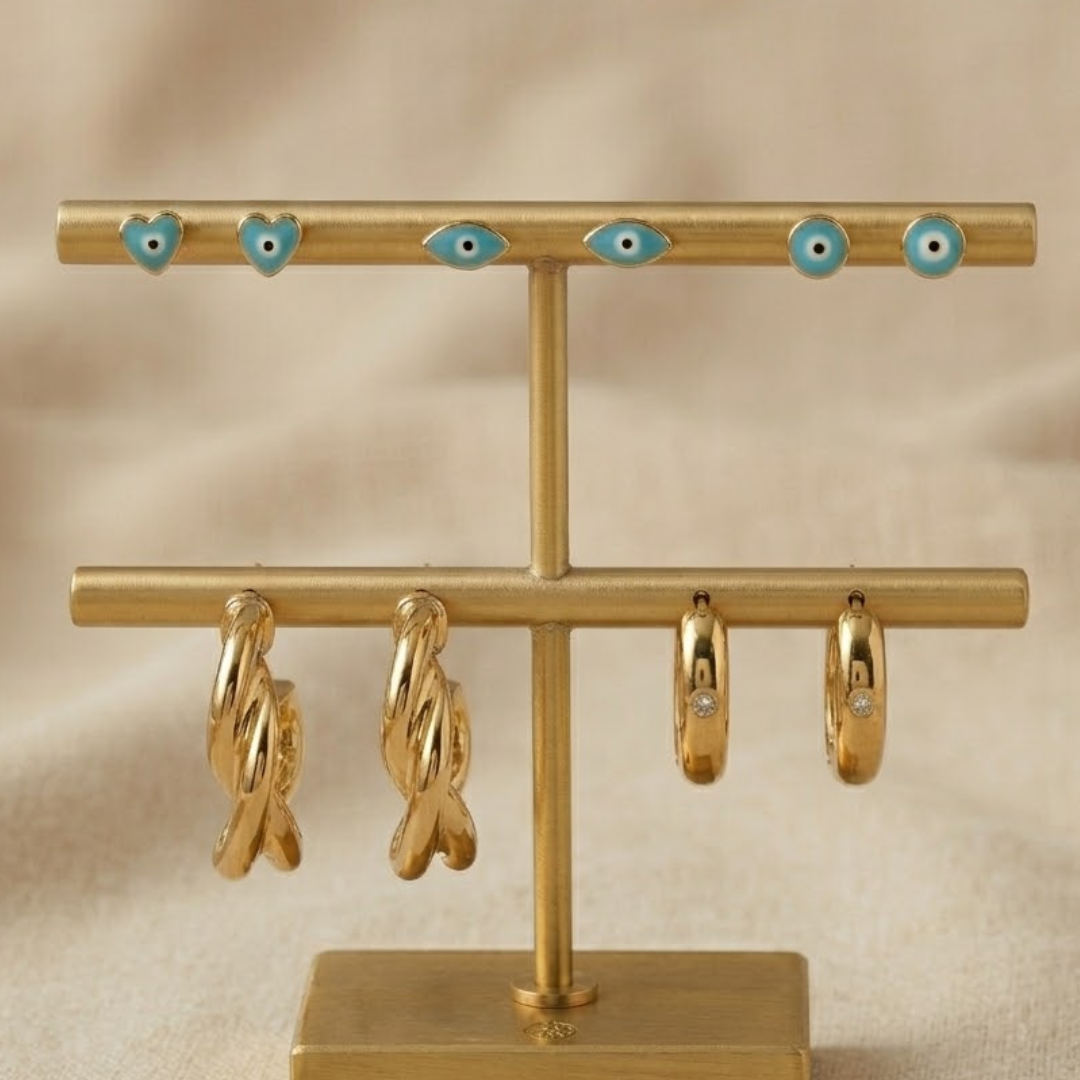 gold evil eye earring stack with enamel evil eye studs, twisted hoop earrings and heart hoop earrings trendy lightweight jewellery