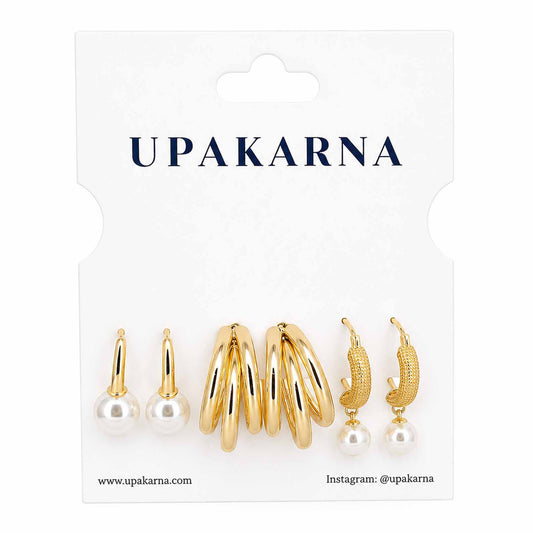 Upakarna gold-tone earring stack featuring pearl stud earrings, layered gold hoop earrings, and textured pearl drop hoop earrings displayed on a branded white jewellery card.