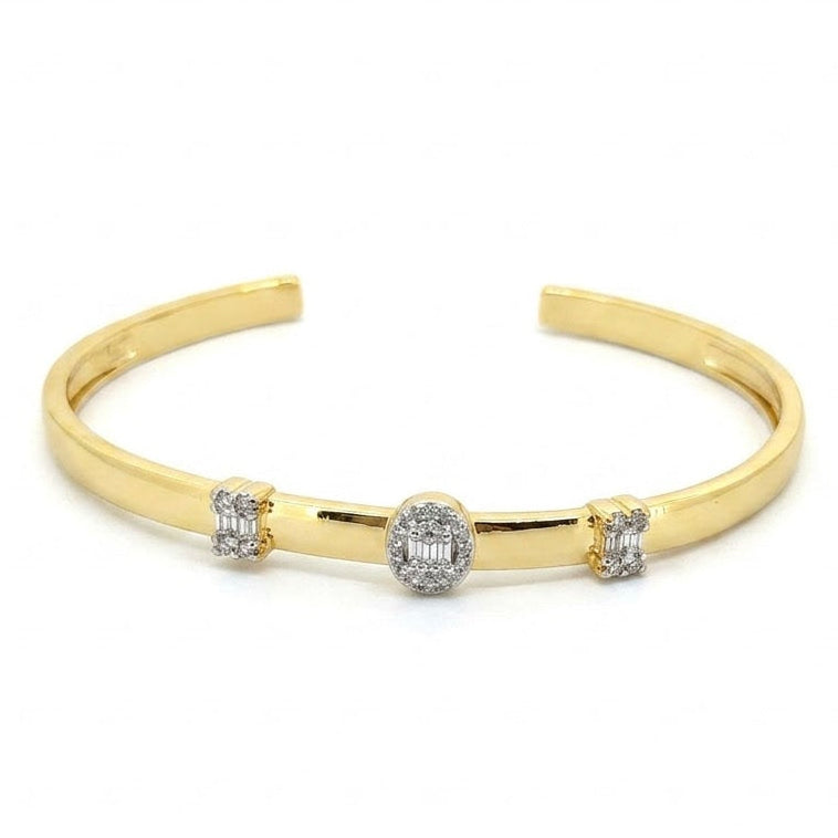 Anti-tarnish yellow gold open cuff bracelet featuring an oval center station and flanking side stations set with baguette-cut and round pavé cubic zirconia clusters.