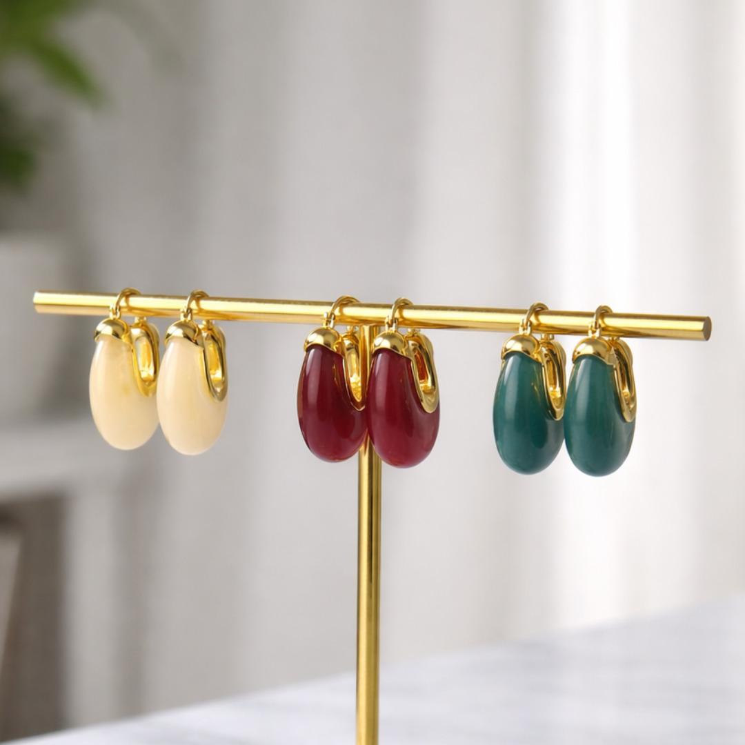 A three-pair earring stack featuring high-gloss resin "wee" hoops in deep sangria red, slate grey, and creamy white on a branded display card.