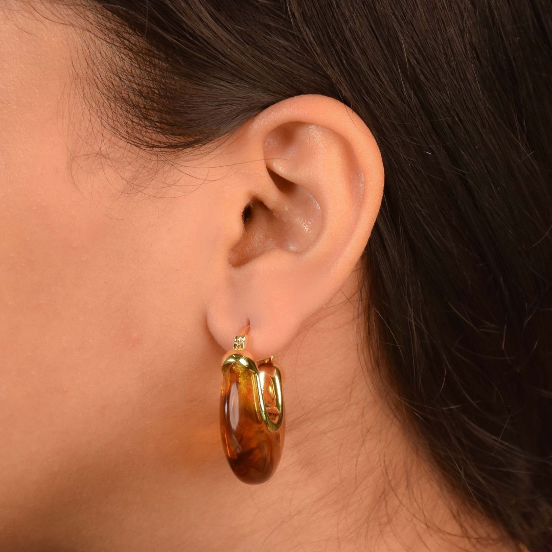 Marbled resin hoops with a glossy swirl design and an anti-tarnish gold finish, perfect for everyday wear and statement styling.