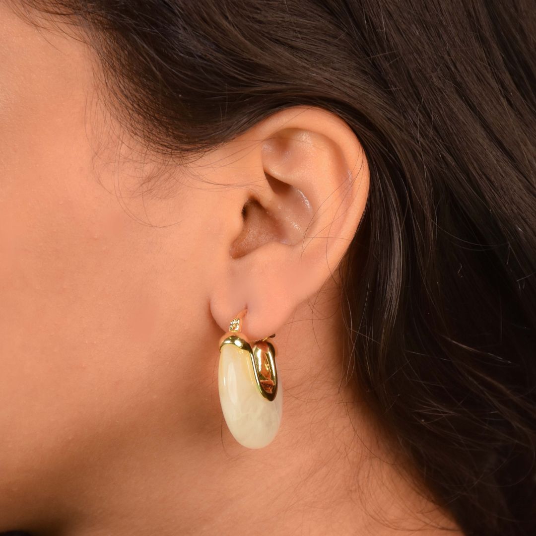 Marbled resin hoops with a glossy swirl design and an anti-tarnish gold finish, perfect for everyday wear and statement styling.