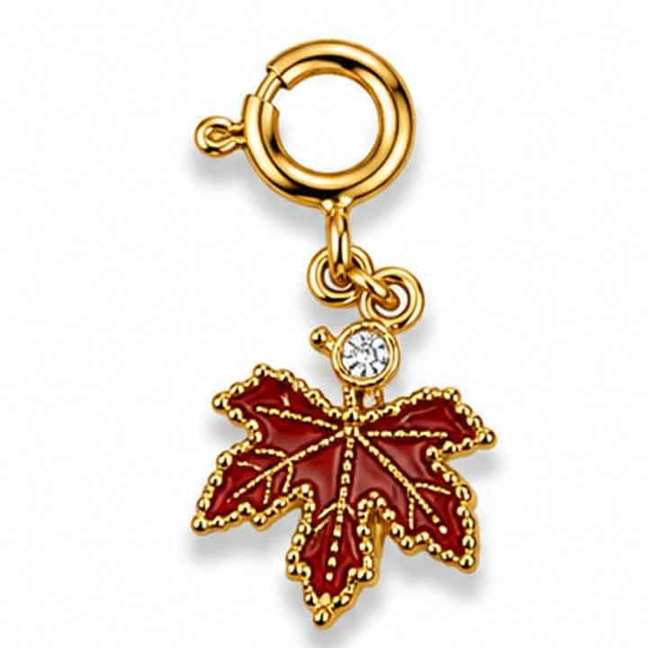 Zoomed-out view of a gold-tone maple leaf-shaped charm with red enamel detailing and a sparkling stone accent, displayed on a clean white background.