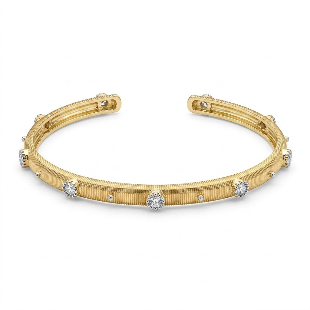 Anti-tarnish yellow gold open cuff bracelet featuring a fine vertically ribbed texture, studded with round clear cubic zirconia halo stations and silver bead accents along the band. on a white background .