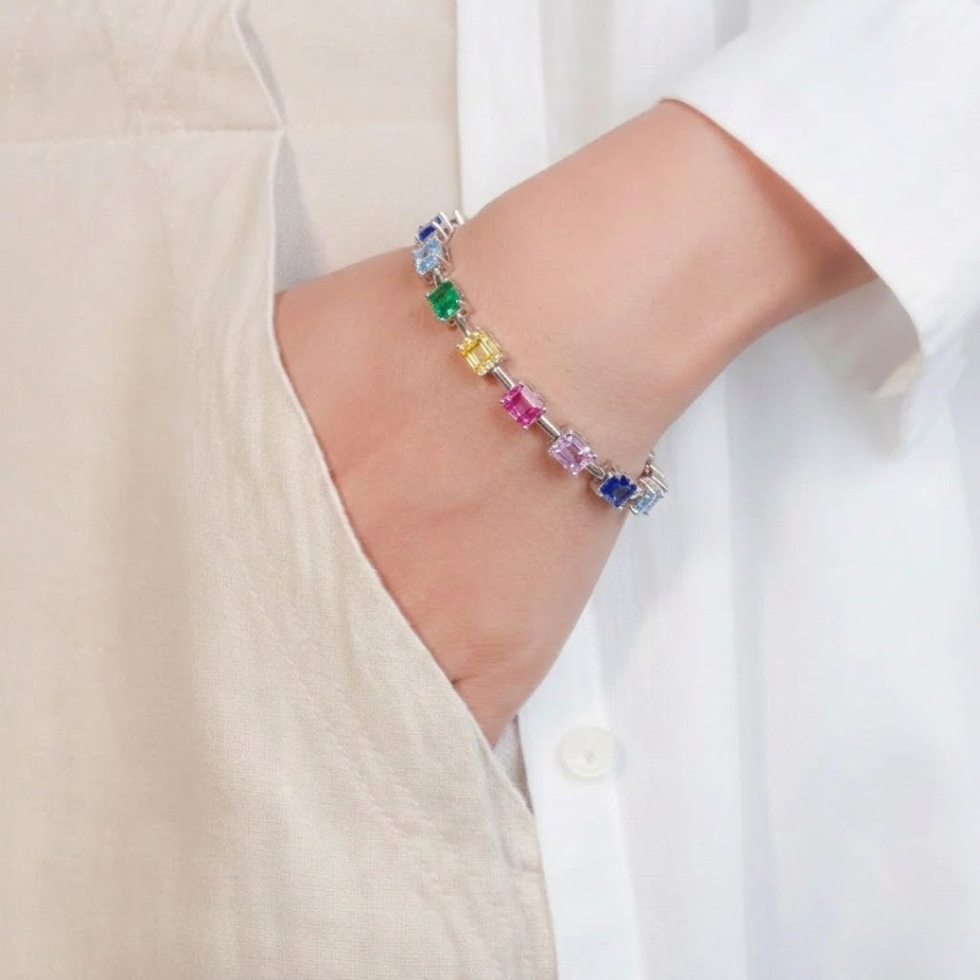 Multi-color baguette gemstone tennis bracelet in a silver box setting.
