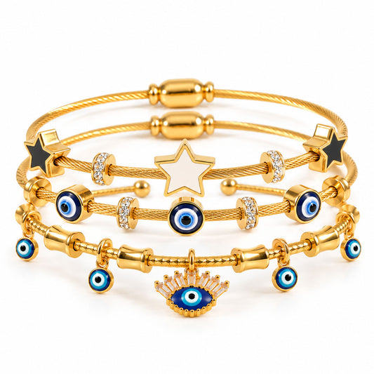 A product photo of a stacked set of gold-tone bracelets featuring twisted cable wire and charm chains adorned with a central white enamel star, black star terminals, rhinestone spacers, blue-and-white evil eye beads, and a dangling evil eye pendant.
