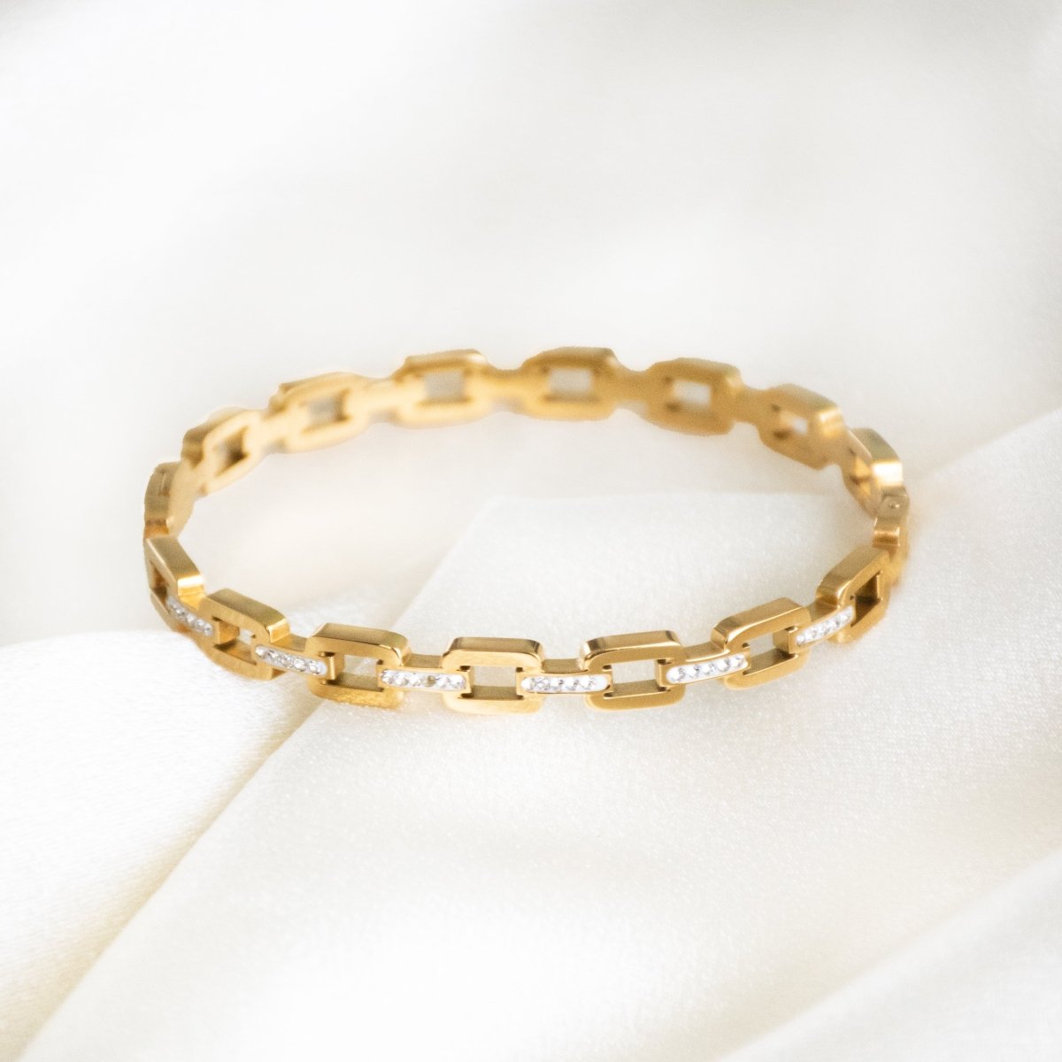 Studded buckle link bangle with sparkling stone detailing and an anti-tarnish finish, available in gold and rose gold, perfect for everyday wear, modern styling, and effortless stacking.