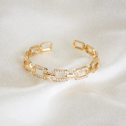 Studded buckle link chain bangle with sparkling stone detailing and an anti-tarnish finish, perfect for everyday wear, modern styling, and thoughtful gifting.