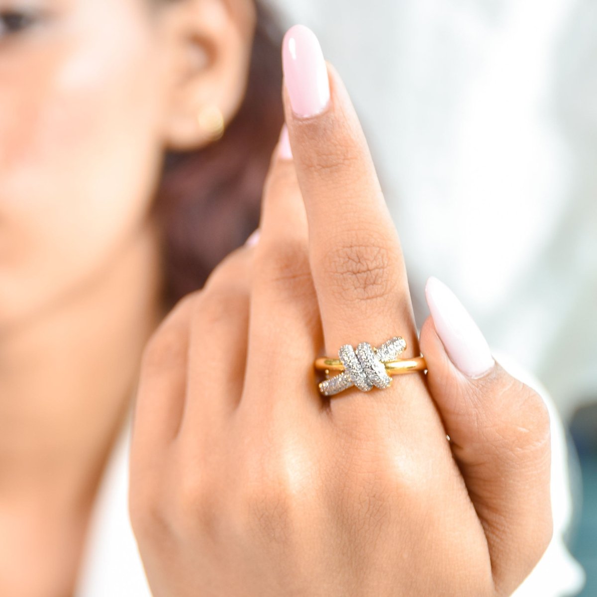Elegant golden knot ring with sparkling pavé detailing and an adjustable anti-tarnish finish, perfect for everyday elegance, stacking, and timeless styling.