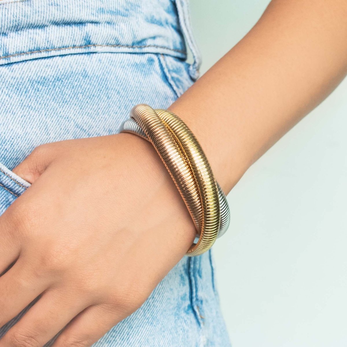 Stylish triple-layer twisted bangle with mixed metallic tones and an anti-tarnish finish, perfect for trendy everyday styling, statement looks, and versatile stacking.