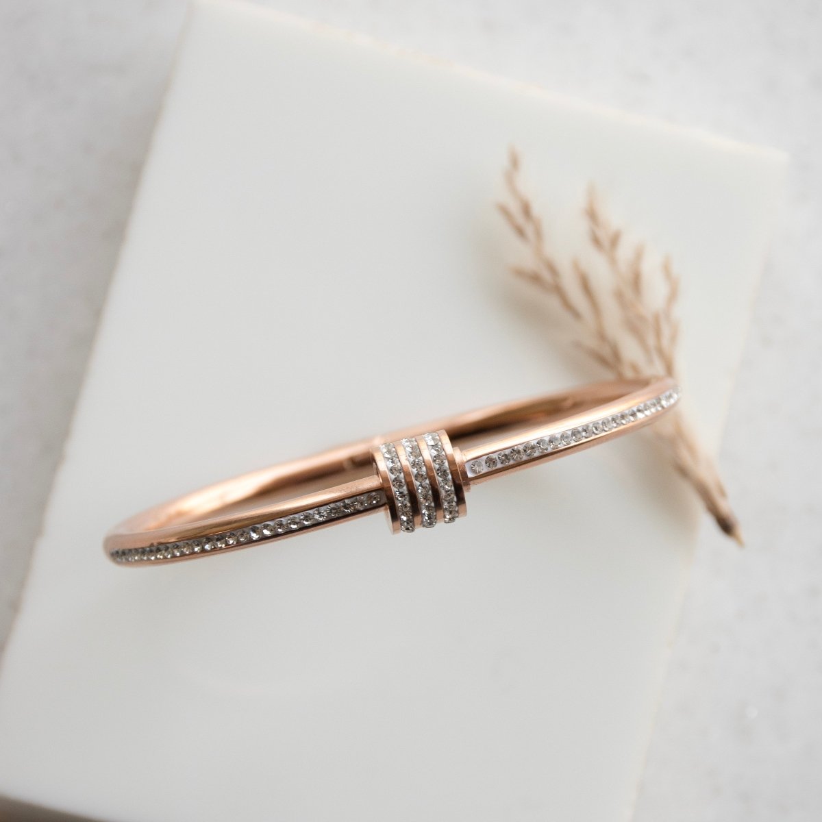 Elegant rosegold twisted sparkle bangle with shimmering stone detailing and an anti-tarnish finish, perfect for everyday glam, casual styling, gifting, and chic layered looks.