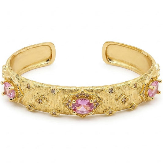 Anti-tarnish textured gold cuff bracelet featuring oval-cut pink gemstone centerpieces set in starburst frames with surrounding diamond-shaped pavé cz crystal accents and a brushed-matte finish.