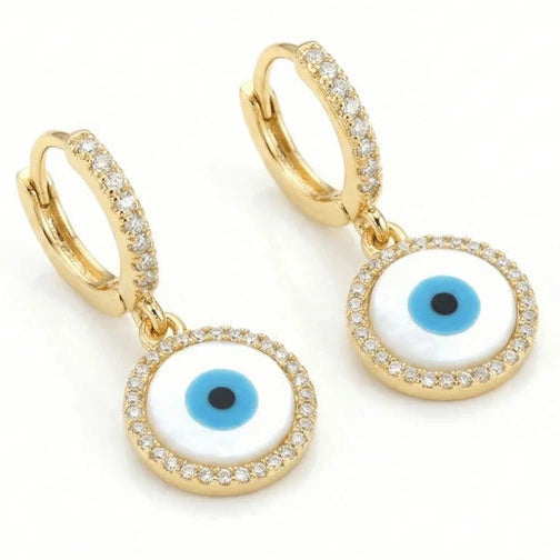 Gold-tone evil eye drop earrings featuring blue-and-white circular eye motifs surrounded by clear crystal accents, suspended from crystal-studded huggie hoops.