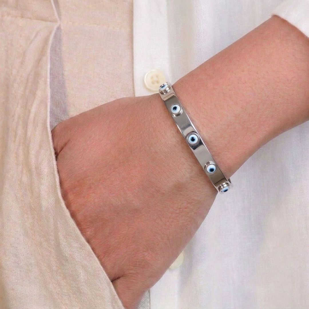 Evil eye bangle with protective charm detailing and an anti-tarnish finish, available in gold and rose gold, perfect for everyday wear, meaningful styling, and effortless stacking.