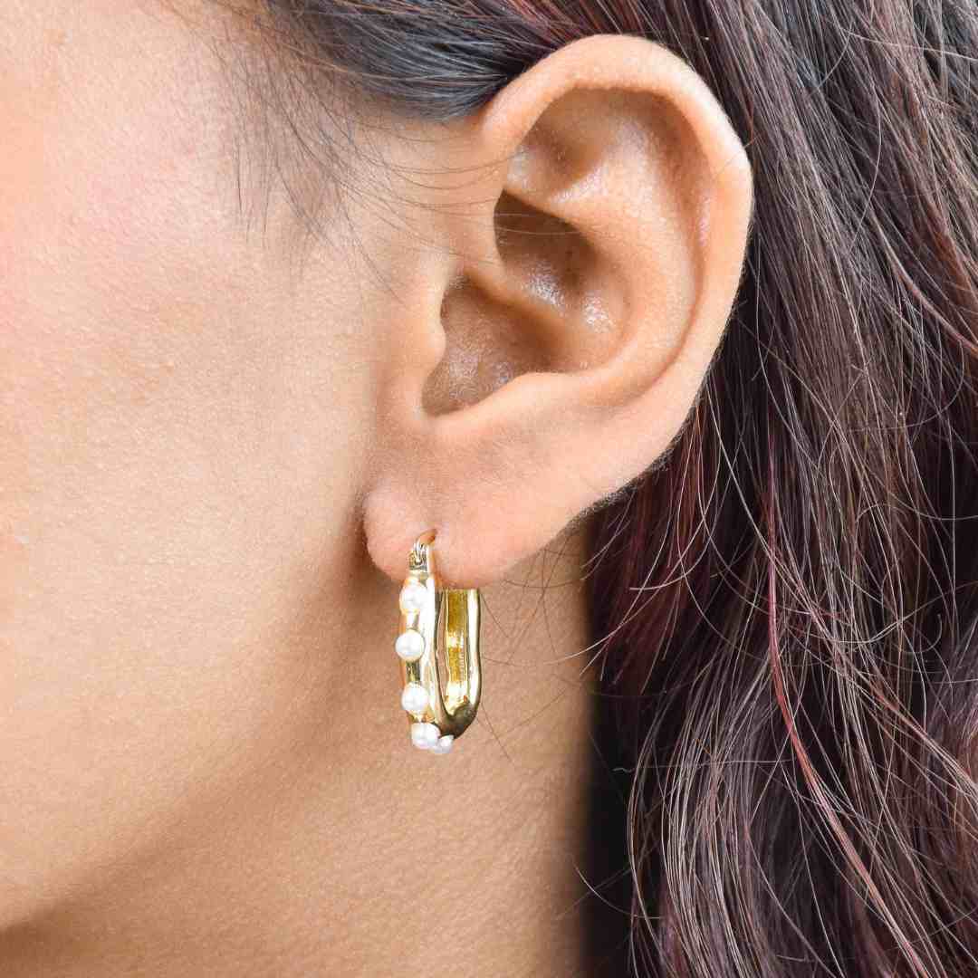Pearl lined hoops with luminous pearl detailing and an anti-tarnish gold finish, perfect for everyday wear and elegant styling.