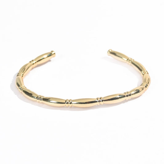 Barrel cuff bangle with a textured segmented design and an anti-tarnish gold finish, perfect for everyday wear, elegant styling, and effortless stacking.