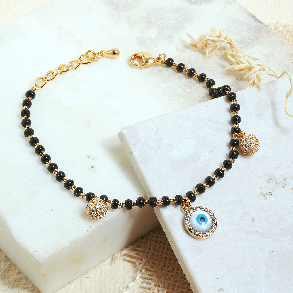 Evil eye mangalsutra bracelet with protective charm detailing and an anti-tarnish gold finish, perfect for everyday wear and meaningful styling.